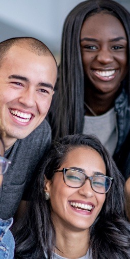 3 diverse teenagers smiling wearing grey 