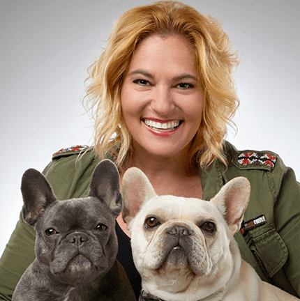 A portrait of Stacey Lombardo holding one grey and one white french bulldog